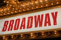 the broadway sign is lit up with lights